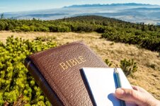 hand-holding-bible-empty-notebook-pencil-outdoor-devotion-study-mountains-high-tatras-vysoke-t...jpg